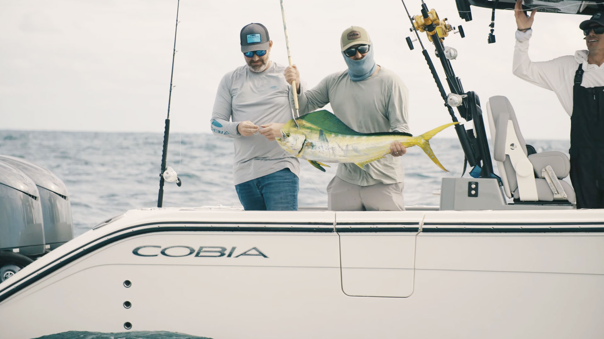 men pulling large fish out of water